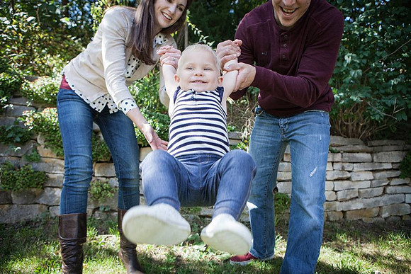 Parents swing child toward camera