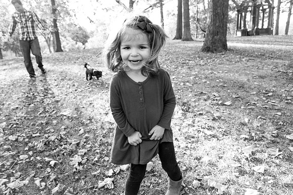 Girl smiles in park at photographer