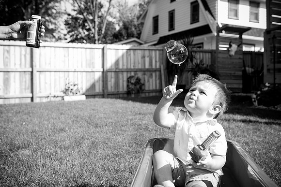 Family plays with bubbles in back yard Milwaukee photo