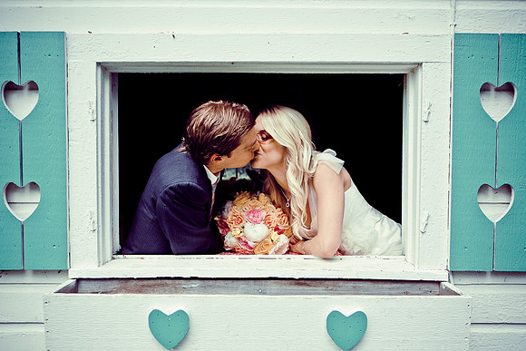 Bride and Groom Kiss in window