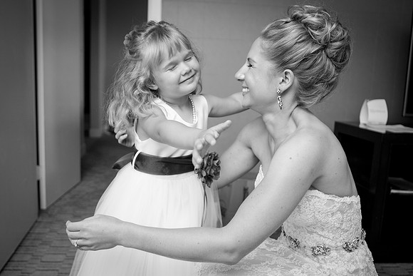 Bride and flower girl hug before wedding